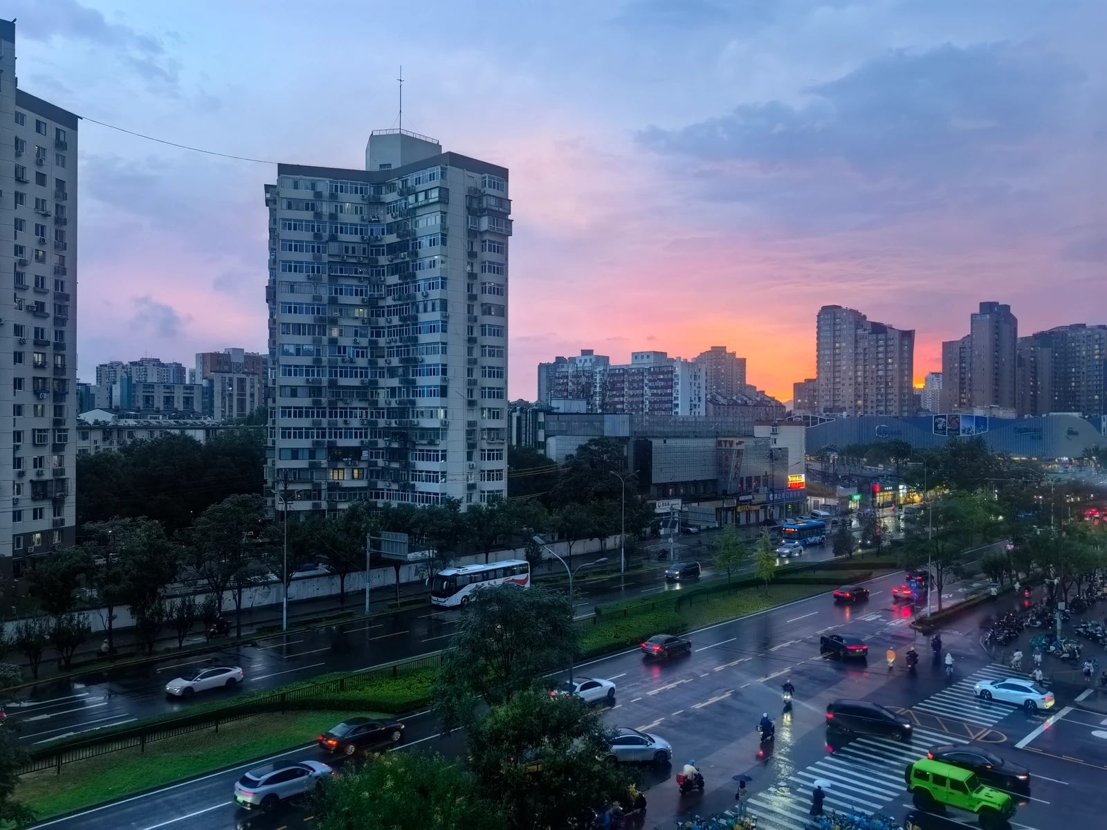 晚霞映照城市楼房与雨后的街道